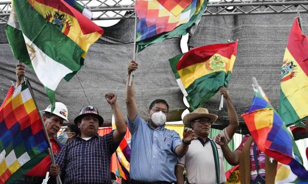 Bolivian President Luis Arres, wearing a mask, waves the Wipala flag - representing the indigenous peoples of the Andes - during a pro-government rally in Santa Cruz, Bolivia. Photo: AIZAR RALDES / AFP
