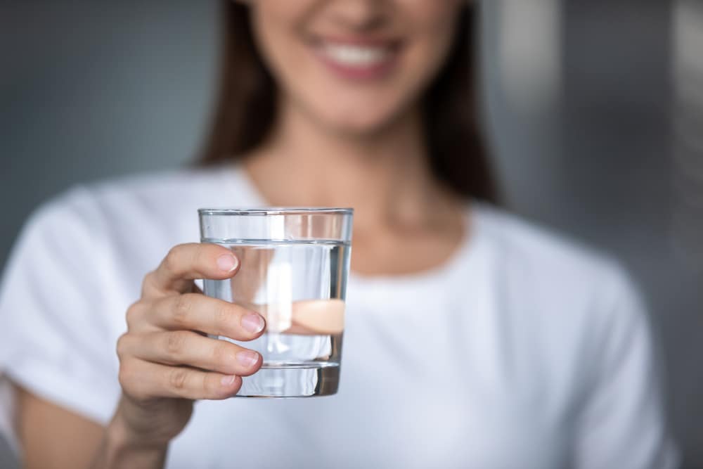 Woman holding a glass of water.