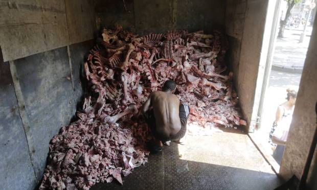 Pain of hunger: A man picks up tallow and meat bones rejected by the market in a truck in Rio de Janeiro.  Unemployment and widespread inflation increase the number of people at risk of food insecurity in Brazil