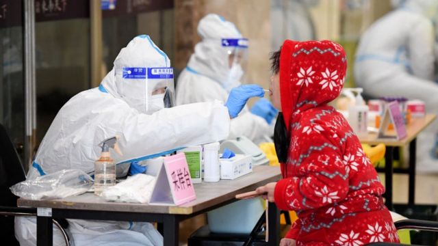 A medical worker collects a sample from a local resident for COVID-19 DNA testing on March 13, 2022 in Changchun, Jilin Province, China